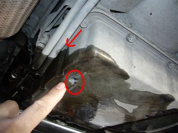 已檢查出在變速箱油底殼破了個洞  箭頭指處是主要漏油處